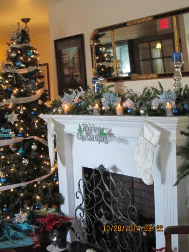 a christmas tree in a living room with a fireplace at Woodstock Inn Bed & Breakfast in Independence