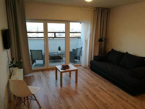 a living room with a couch and a table at Haas Apartments Stojanova with Parking in Brno