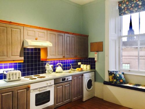 a kitchen with a stove top oven next to a window at Royal Mile St Giles St in Edinburgh