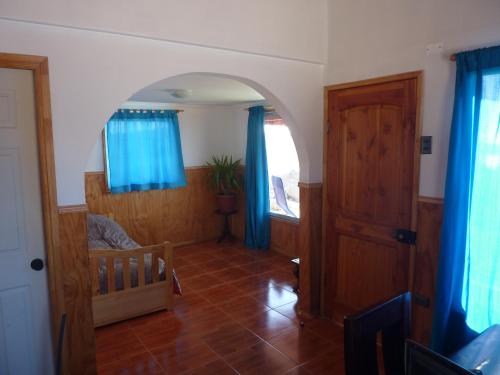 sala de estar con arcos y cortinas azules en Cabaña Ecológica Trotamundos, en Coquimbo