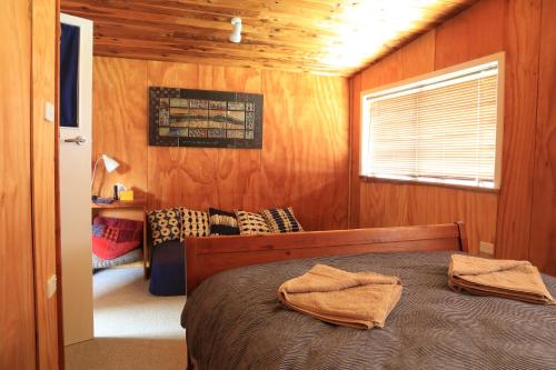 1 dormitorio con 1 cama con 2 toallas en Earthbridge, en Hikutaia