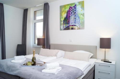 a white bedroom with a bed with a bottle of champagne at Südkap H-08 in Pelzerhaken