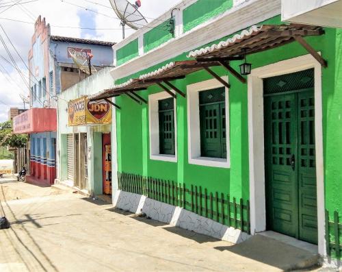 a green and white building on the side of a street at Pousada Recanto Verde in Sao Benedito do Sul