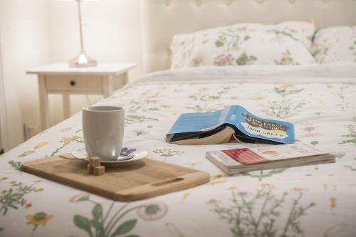 a tray with a cup and a book on a bed at Gite du Survenant Montreal in Montréal