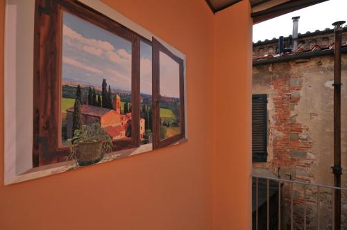 an orange wall with a painting of a view from a window at B&B Il Grifone in Pistoia