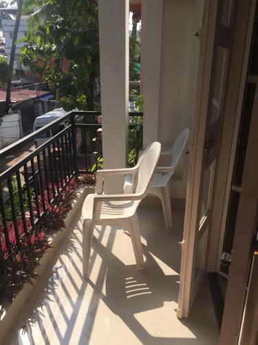 two white chairs sitting on a porch at Nathans Holiday Home in Cochin