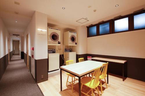uma cozinha e sala de jantar com mesa e cadeiras em White Hostel Shinsaibashi em Osaka