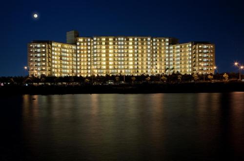 a large building at night with the moon in the sky at Moon Ocean Ginowan Hotel & Residence in Ginowan