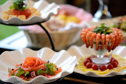 a table topped with plates of food with corn on the cob at Moon Ocean Ginowan Hotel & Residence in Ginowan