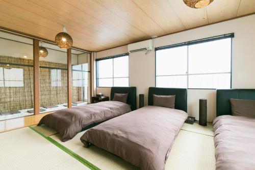 dwa łóżka w pokoju z oknami w obiekcie Okinawa Naha Nishi w mieście Naha