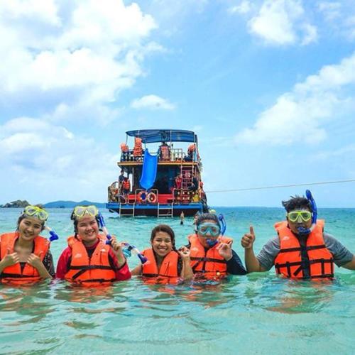 a group of people in the water in front of a boat at Anyamanee Resort Trat in Trat