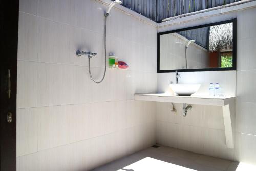 y baño con lavabo y ducha. en MolaMola House, en Nusa Lembongan