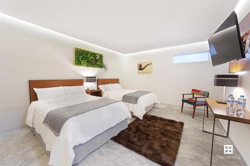 ein Hotelzimmer mit 2 Betten und einem TV in der Unterkunft Hotel Urban 101 in Chetumal