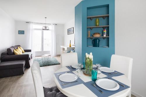 une salle à manger avec une table blanche et des chaises blanches dans l'établissement Le Suroit by Cocoonr, à Saint-Malo