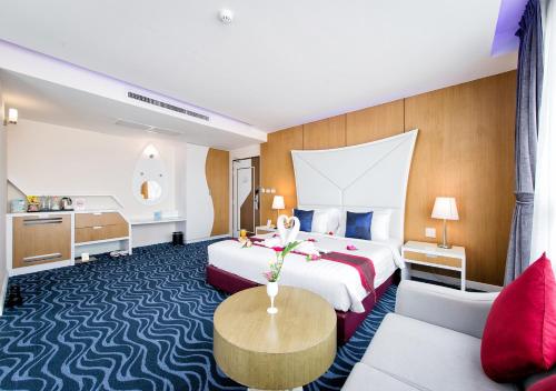 ナコンサワンにあるThe Paradiso JK Design Hotelのベッド2台とソファが備わるホテルルームです。