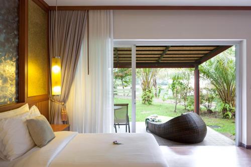 a bedroom with a large bed and a large window at Beyond Khaolak in Khao Lak