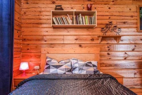 a bedroom with a bed and a wooden wall at Svajonių Dvaras in Balninkai