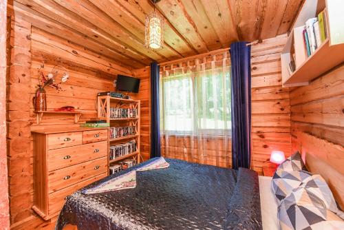 a log cabin bedroom with a bed and a window at Svajonių Dvaras in Balninkai