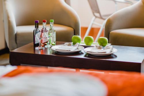 a table with plates and wine bottles on it at Napa Plaza Hotel (Adults Only) in Ayia Napa