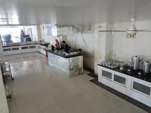 eine Küche mit einer Theke und eine Person in der Küche in der Unterkunft Melasti Beach Resort & Spa Legian in Legian