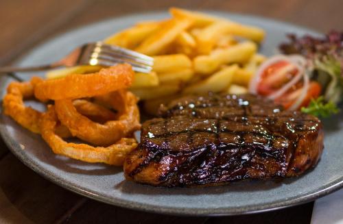 un plato de comida con filete y papas fritas en Skilpadvlei Wine Farm, en Stellenbosch