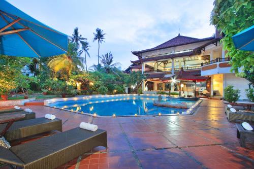 a swimming pool in front of a building at Puri Naga Beachfront Cottages in Legian