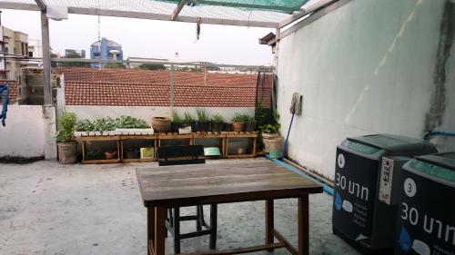 a wooden bench sitting in a room with plants at Natcha Place Rangsit Donmuang in Ban Talat Rangsit