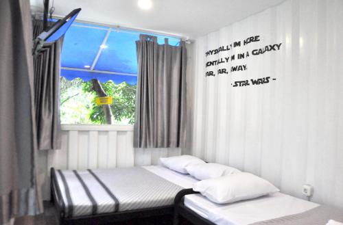 a room with two beds and a window at Hau Eco Lodges Citumang Pangandaran in Pangandaran