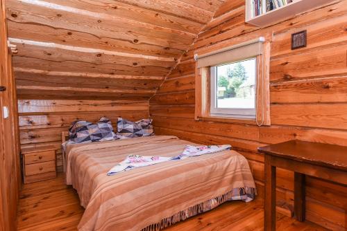 a bedroom with a bed in a log cabin at Svajonių Dvaras in Balninkai