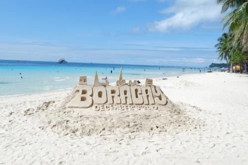 
a beach with a beach chair and some sand at Chateau De Boracay in Boracay
