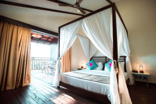 Un dormitorio con una cama con dosel y un balcón. en SinQ Beach Morjim, en Morjim