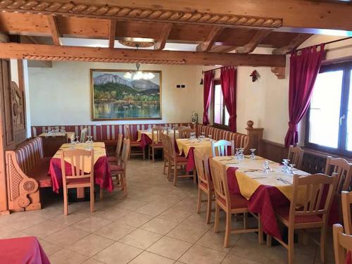 a restaurant with tables and chairs in a room at Hotel Sole del Baldo in Brentonico