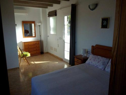 Schlafzimmer mit einem Bett, einer Kommode und einem Spiegel in der Unterkunft Can Vich in Santanyi