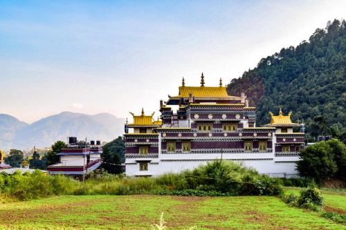 a large building with gold domes on top of a field at Solid Rock - Lodge & Restaurant in Pharping