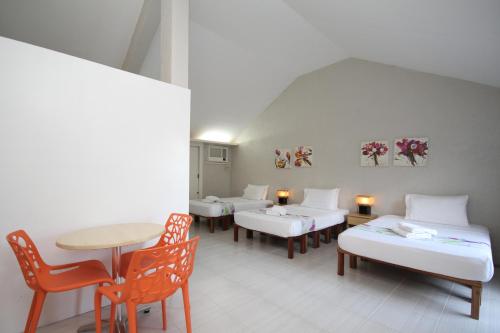 a room with several beds and a table and chairs at MR Holidays Hotel in Boracay