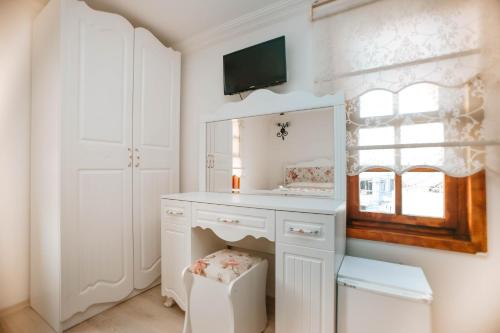 a white bathroom with a sink and a mirror at Patio Hotel in Antalya