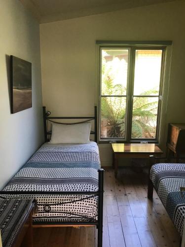a bedroom with two beds and a window at Port Campbell Guesthouse & Flash Packers in Port Campbell