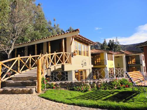 ein Haus mit einer Veranda und einer Treppe davor in der Unterkunft Hotel Pisonay Pueblo in Urubamba