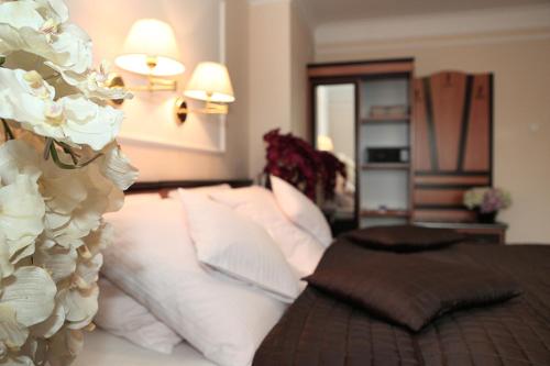 a bedroom with a bed with white pillows at Wzgórze Toskanii Conferences & Restaurant in Przeźmierowo