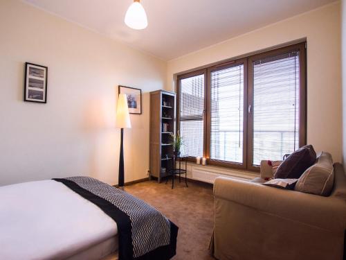 コウォブジェクにあるVacationClub - Olympic Park Apartment B606のベッドルーム1室(ベッド1台、ソファ、窓付)