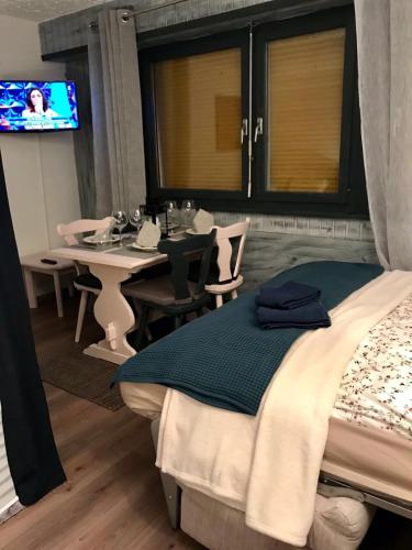 a bedroom with a bed and a table and a television at Studio in Les Collons