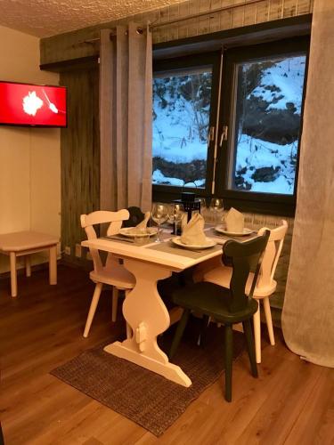 a table and chairs in a room with windows at Studio in Les Collons