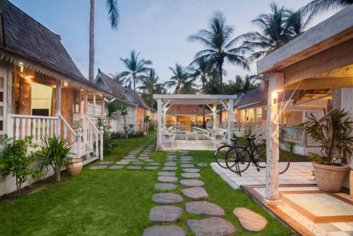 a backyard of a house with a walkway at Palmeto Village in Gili Trawangan