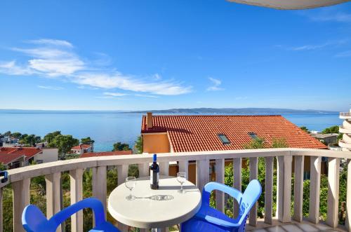 a table and chairs on a balcony with a view of the water at Apartments Mare in Brela