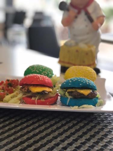 a plate of hamburgers and other foods on a table at Concord Plaza in Hafr Al Baten