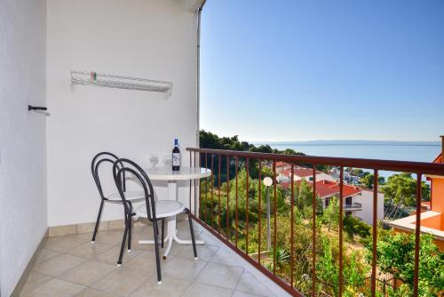 a balcony with a table and chairs and the ocean at Apartments Mare in Brela