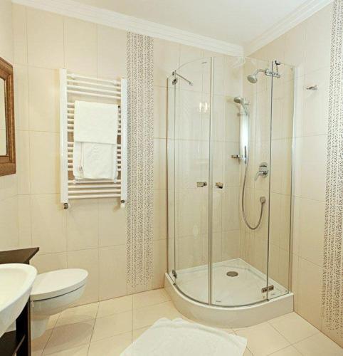 a bathroom with a shower and a toilet and a sink at Wzgórze Toskanii Conferences & Restaurant in Przeźmierowo