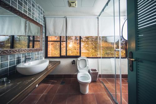 a bathroom with a toilet and a tub and a sink at Sunday Home in Dayin