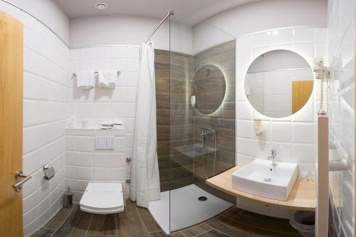 a bathroom with a sink and a shower and a toilet at Boutique Hotel St Georgije in Banja Luka