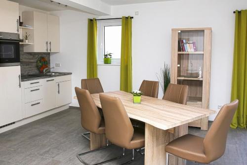 a kitchen and dining room with a wooden table and chairs at Jakobshof in Bad Mergentheim